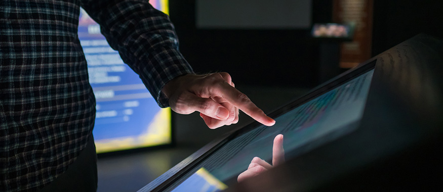 Close up of someone using a digital kiosk.