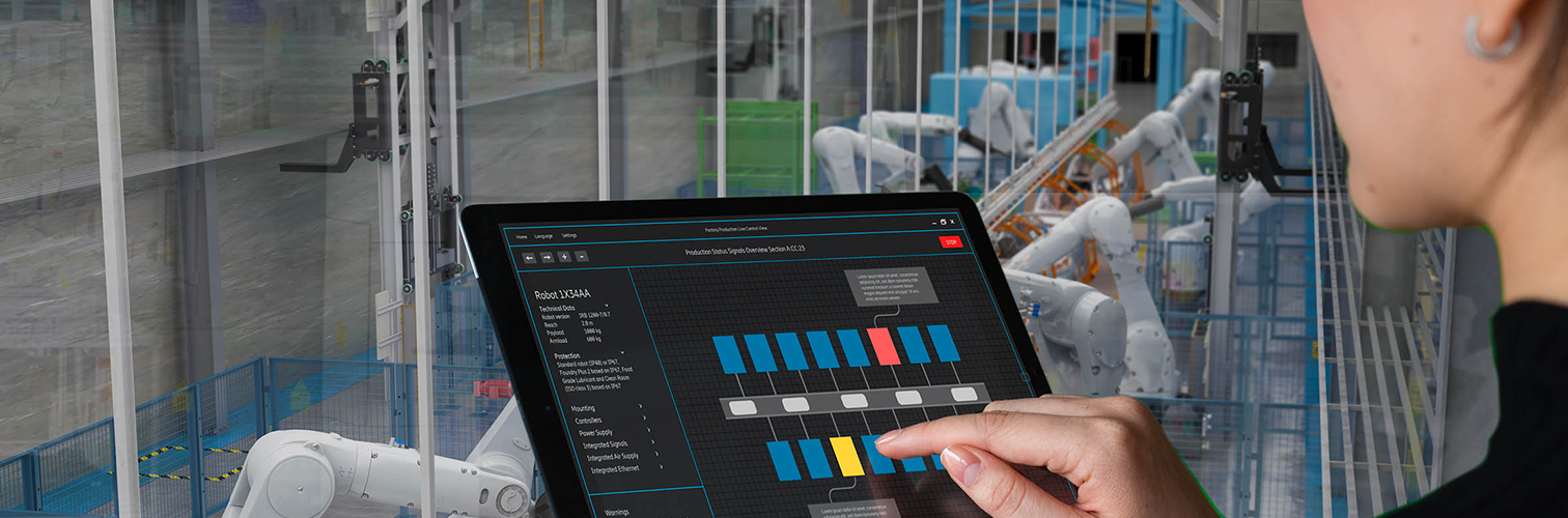 A woman monitoring autonomous robots in an automotive manufacturing facility.