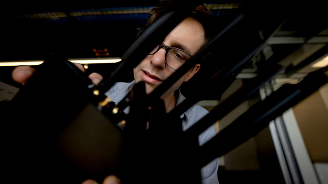 Close-up of a person installing a compact wireless router, holding a unit with several black antennas